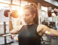 Frau im Fitnesstudio beim Gewichte heben